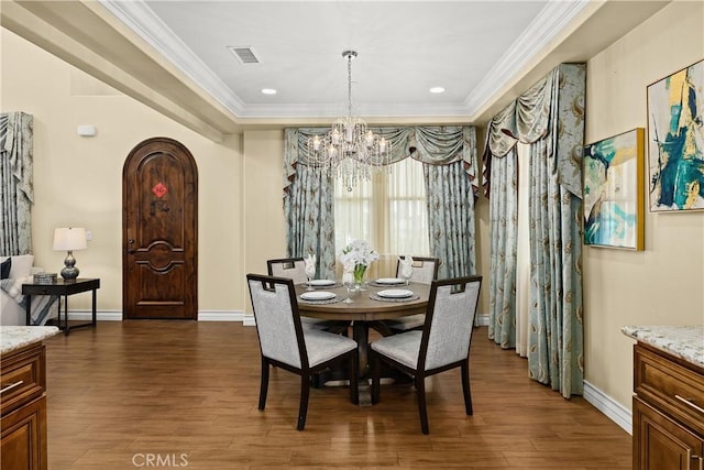dining room with crown molding, a chandelier, visible vents, and dark wood-type flooring