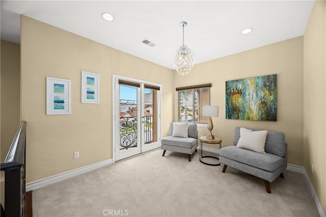 living area featuring visible vents, baseboards, a notable chandelier, and light carpet