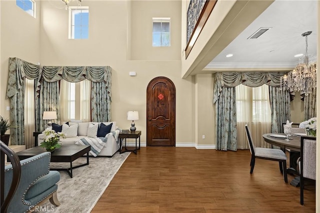 interior space with an inviting chandelier, a wealth of natural light, and wood finished floors