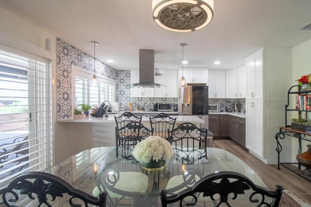dining area featuring a toaster, light wood-style flooring, and visible vents