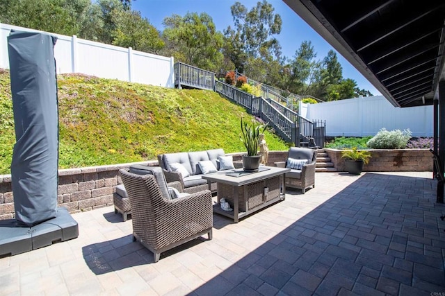view of patio / terrace with an outdoor living space, a fenced backyard, and stairs