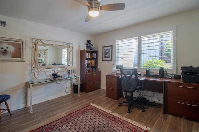 office featuring a ceiling fan, visible vents, and wood finished floors