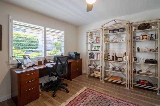 home office with a ceiling fan, baseboards, and wood finished floors