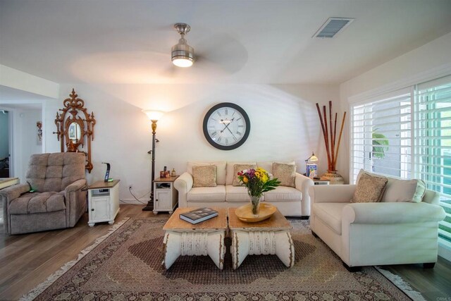 living area with visible vents, ceiling fan, and wood finished floors