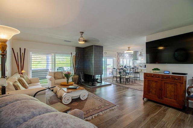 living area featuring visible vents, ceiling fan, and wood finished floors