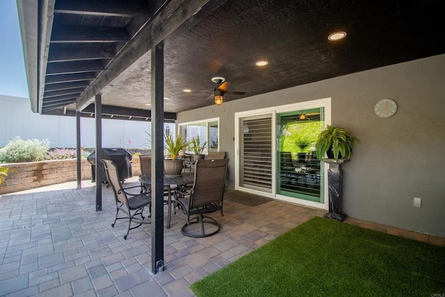 view of patio with outdoor dining space, ceiling fan, and a grill