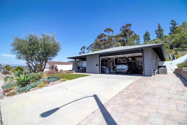 view of front facade featuring a garage, fence, driveway, and cooling unit