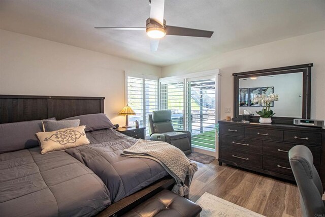 bedroom with a ceiling fan, wood finished floors, and access to exterior