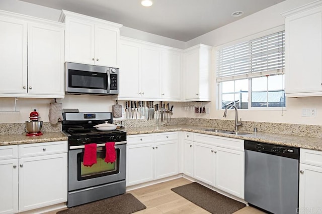 3524 Lone Pine Ln, San Marcos, CA 92078 - kitchen featuring appliances with stainless steel finishes, a sink, light stone counters, white cabinets, and light wood-style floors