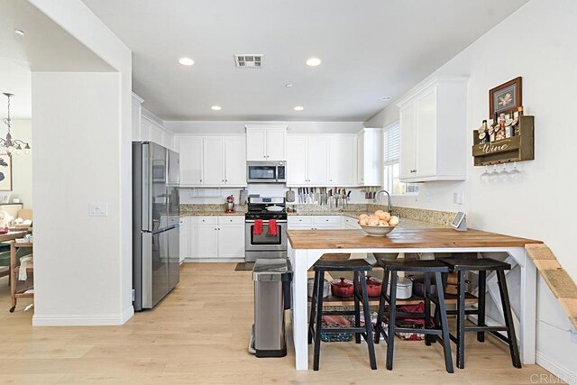 3524 Lone Pine Ln, San Marcos, CA 92078 - kitchen with light wood-type flooring, visible vents, white cabinets, and stainless steel appliances