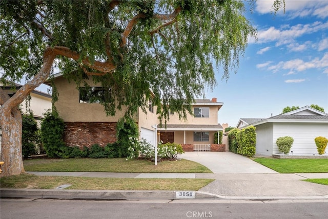 view of front of home featuring a porch, a front yard, a garage, concrete driveway, and stucco siding