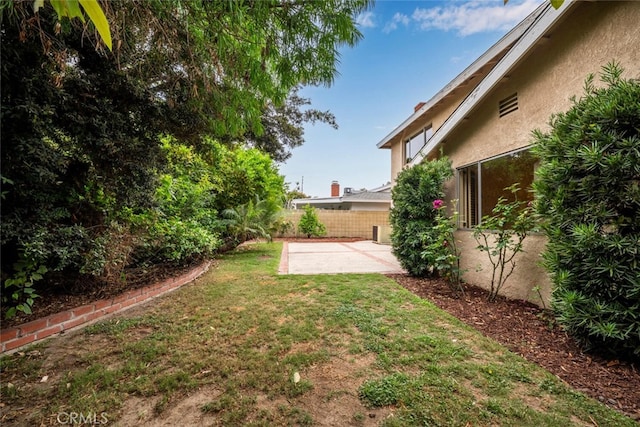 view of yard featuring fence and a patio