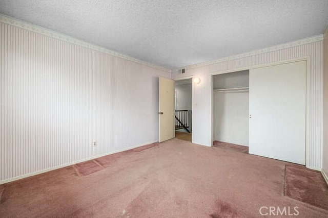 unfurnished bedroom with a closet, carpet flooring, and a textured ceiling