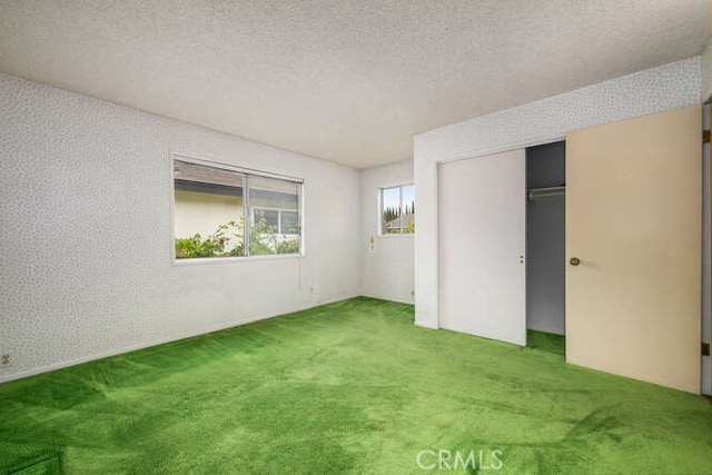 unfurnished bedroom featuring a closet, carpet flooring, and a textured ceiling