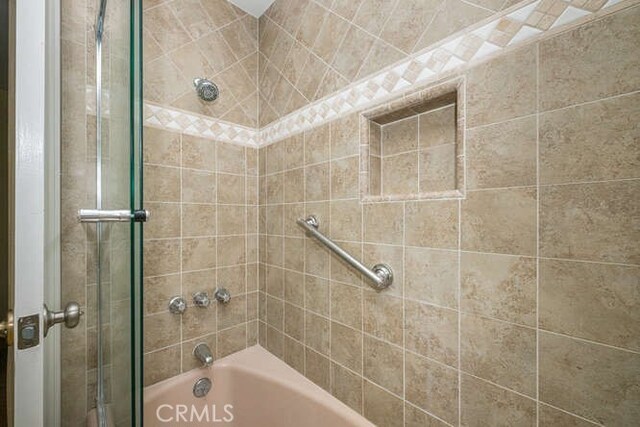 bathroom with combined bath / shower with glass door