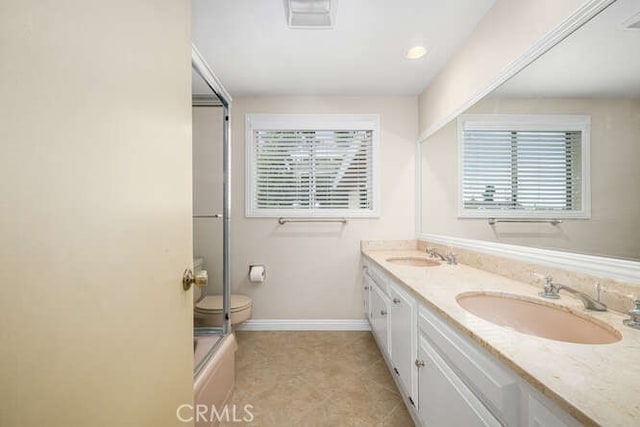 bathroom with a sink, baseboards, double vanity, and visible vents