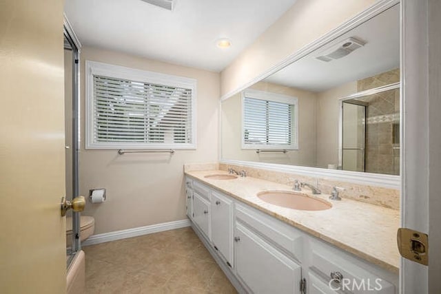 full bathroom with a sink, a shower with shower door, and a healthy amount of sunlight