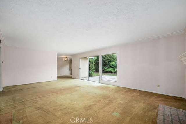 unfurnished living room with an inviting chandelier, a textured ceiling, carpet, and baseboards