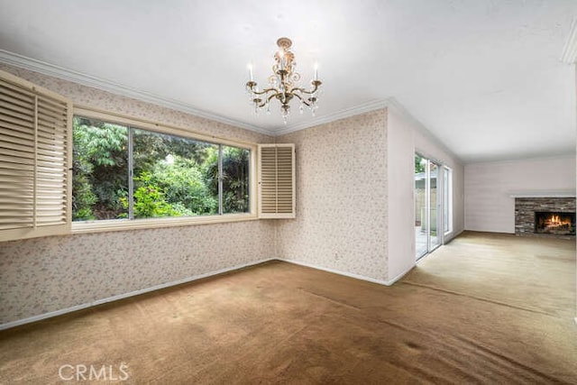 interior space with an inviting chandelier, crown molding, carpet floors, a fireplace, and wallpapered walls