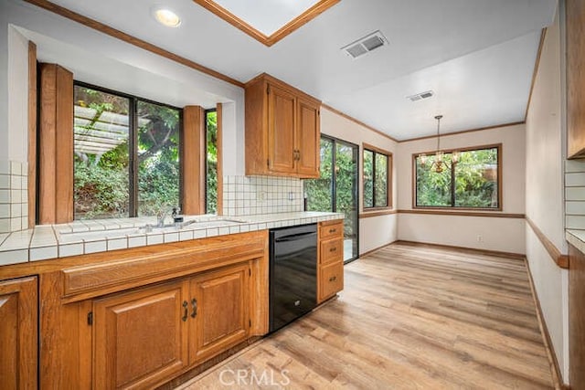 kitchen featuring visible vents, backsplash, brown cabinets, and dishwasher