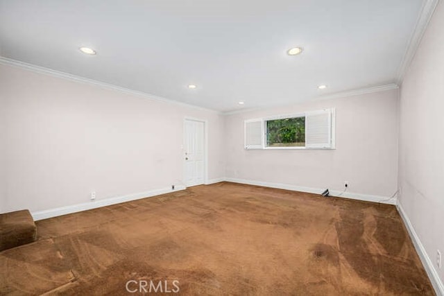 spare room featuring crown molding, carpet, and baseboards