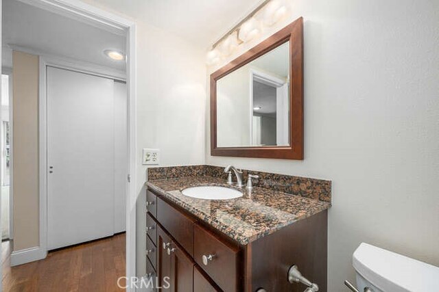 bathroom featuring vanity, toilet, and wood finished floors