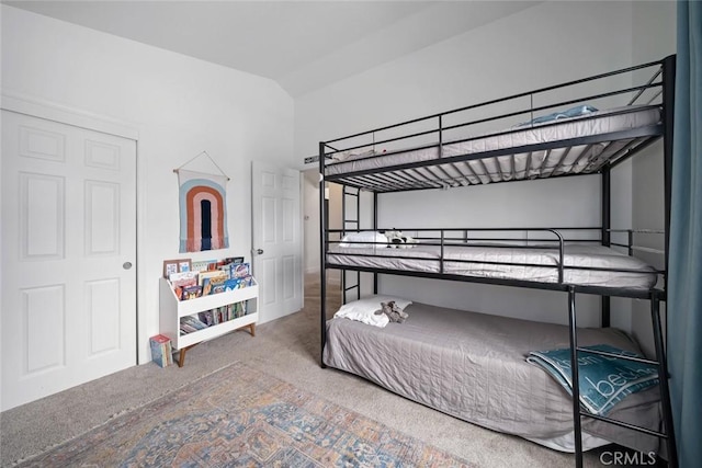 carpeted bedroom with baseboards and lofted ceiling
