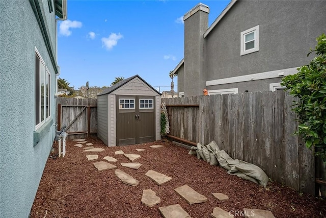 view of yard with a storage shed, an outdoor structure, and a fenced backyard