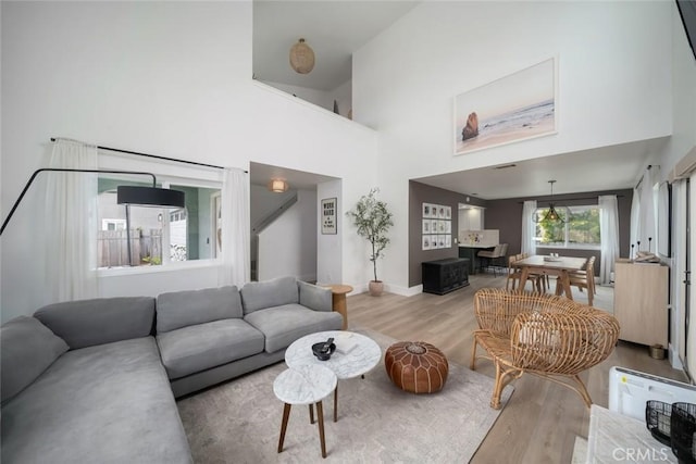 living room with wood finished floors and a towering ceiling