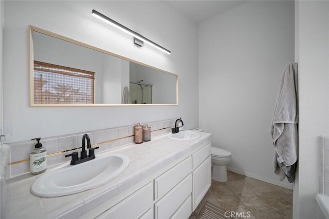 full bathroom featuring double vanity, a sink, an enclosed shower, and toilet