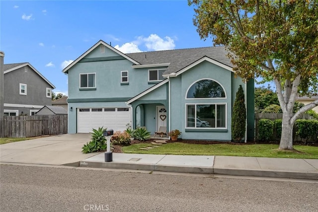 traditional-style home with fence, an attached garage, a front lawn, stucco siding, and concrete driveway