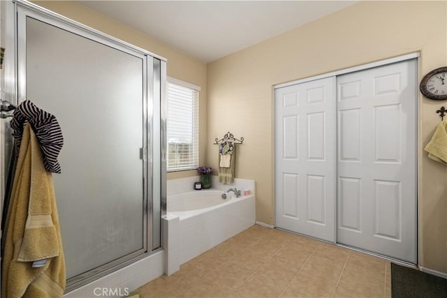 full bathroom featuring tile patterned floors, baseboards, a shower stall, and a bath