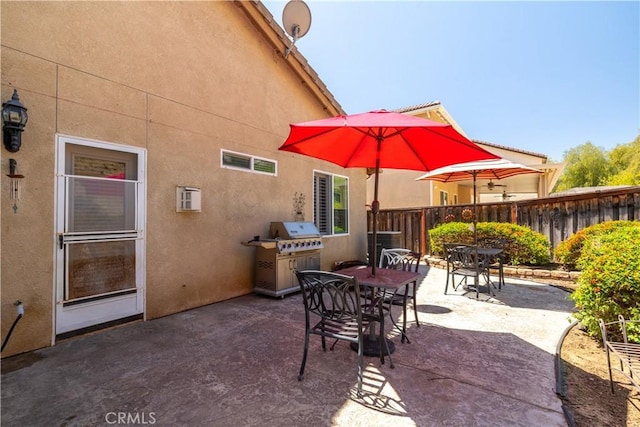 view of patio with grilling area, fence, and outdoor dining area