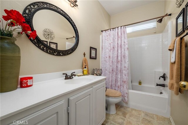 full bathroom featuring toilet, shower / bath combo with shower curtain, and vanity