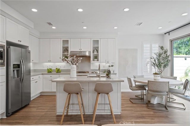 125 Annuals, Irvine, CA 92618 - kitchen featuring a kitchen breakfast bar, appliances with stainless steel finishes, wood finished floors, a sink, and white cabinetry