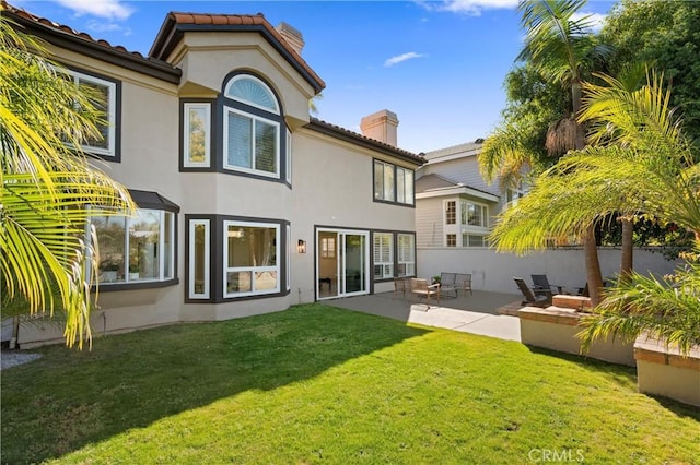 101 Fairlane Rd, Laguna Niguel, CA 92677 - back of property featuring a lawn, a patio area, stucco siding, and a chimney