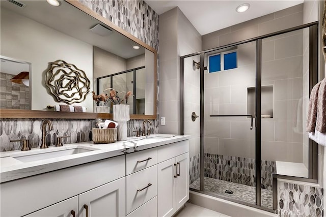 full bathroom featuring double vanity, a sink, recessed lighting, and a shower stall