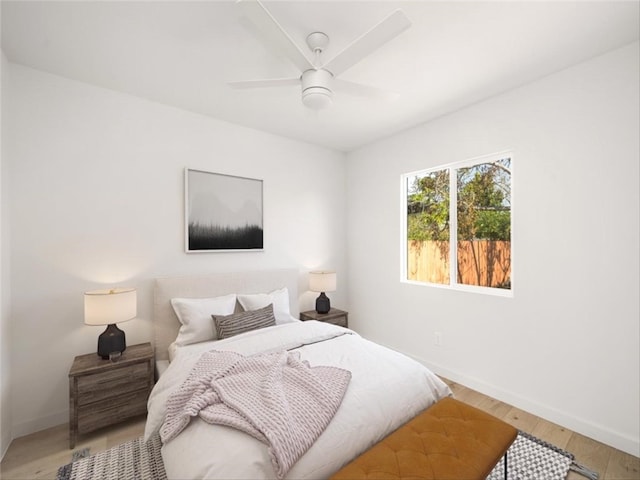 bedroom featuring baseboards, a ceiling fan, and light wood-type flooring