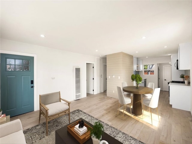 living room with light wood-style floors, a heating unit, and recessed lighting