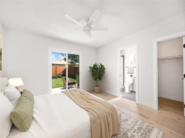 bedroom with a walk in closet, ceiling fan, ensuite bathroom, light wood-style floors, and access to outside