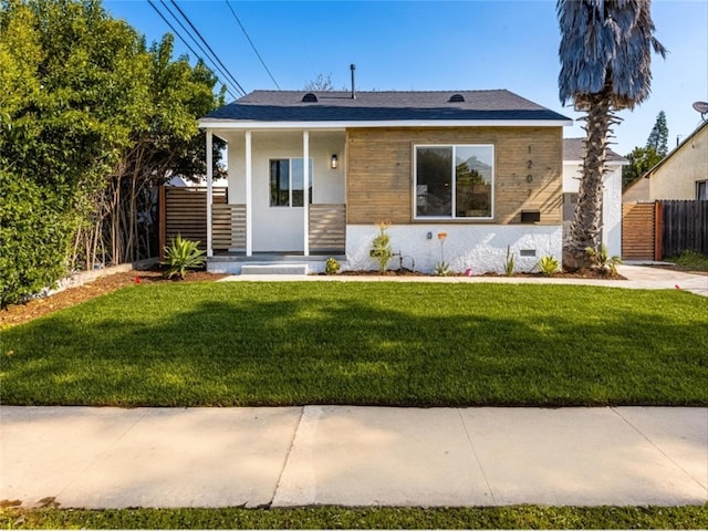 bungalow-style house with fence and a front lawn