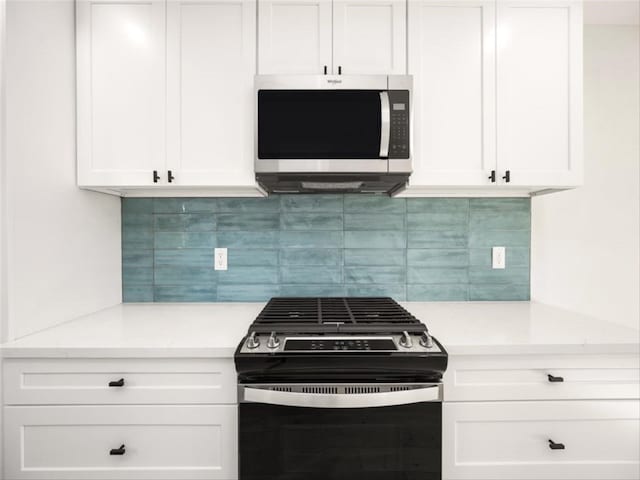 kitchen featuring light countertops, decorative backsplash, stainless steel microwave, and range with gas stovetop