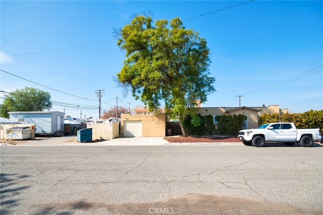 584 E H St Unit 1-11, Colton, CA 92324 - view of front of house featuring fence, concrete driveway, and a garage