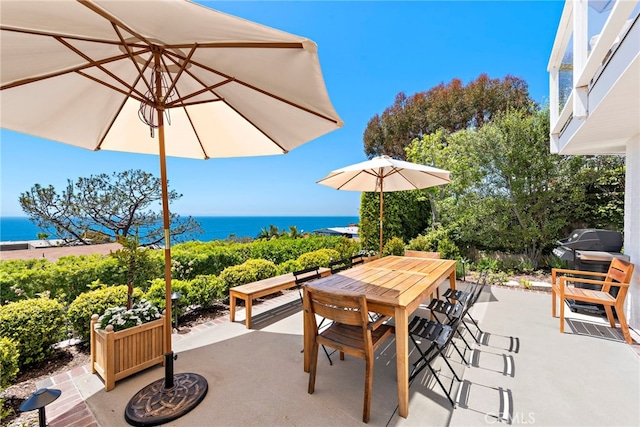 view of patio / terrace featuring a water view and outdoor dining space