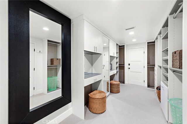 spacious closet with light colored carpet and visible vents