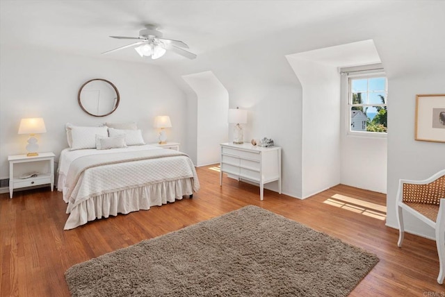 bedroom featuring ceiling fan, vaulted ceiling, and wood finished floors