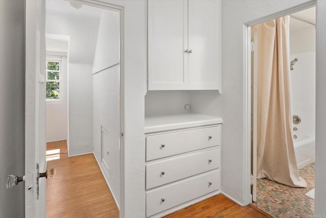 hall with baseboards and light wood finished floors