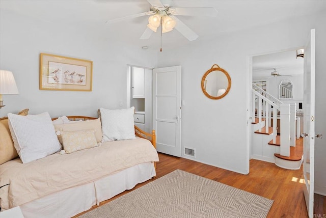 bedroom with baseboards, ceiling fan, visible vents, and wood finished floors