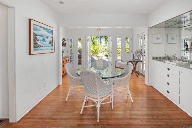 dining area featuring french doors and light wood-style flooring