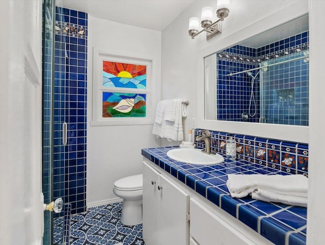 full bath featuring toilet, tiled shower, tile patterned flooring, and vanity